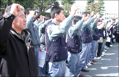 민주노총 경남본부 이흥석 본부장(왼쪽)이 노동자들과 함께 구호를 외치고 있다. 